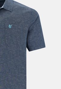 Chemise à manches courtes, bleu marine en tissu texturé avec un motif subtil. Dispose d'une poche poitrine et d'un logo bleu clair sur le côté gauche.