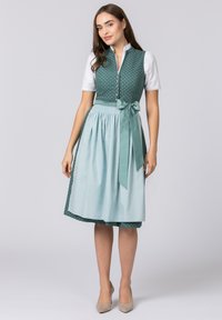 Green and light blue dirndl dress with polka dots, fitted bodice, white blouse, and a satin bow at the waist. Textured fabric.