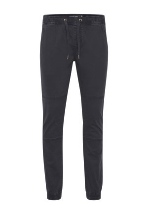 Black jogger pants made of cotton blend fabric, featuring an elastic waistband with drawstring, tapered legs, and side pockets.