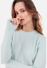 Pull côtelé vert menthe clair en matière douce, doté d'un col rond et de manches longues avec une coupe ample.