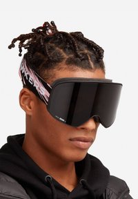 Gafas de esquí con una gran lente negra, una banda elástica negra y rosa con la inscripción "HAWKERS" y un sellado de espuma suave para mayor comodidad.
