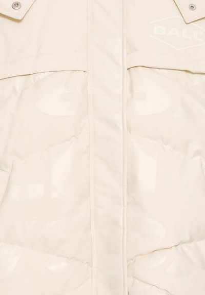 Bēša šūta jaka priekšpusē ar redzamām šuvēm, pogas ar sprādzēm pie apkakles un vāji izcelts "BALL" logo augšējā labajā krūšu daļā.