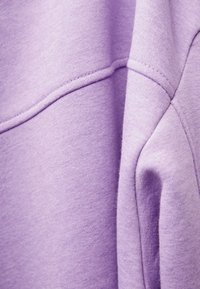 Felpa viola dal texture morbido, con scollatura rotonda e dettagli delle cuciture. Il tessuto presenta un motivo a maglia uniforme.