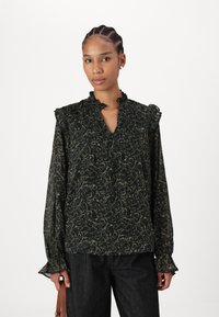 Svart bluse med blomstermønster i grønt. Har volanger ved halslinningen og mansjettene. Lange ermer, lett og semi-transparent stoff.