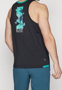 Camiseta sin mangas de entrenamiento negra con un gráfico geométrico turquesa y un logo en la parte posterior, con un escote turquesa en contraste.