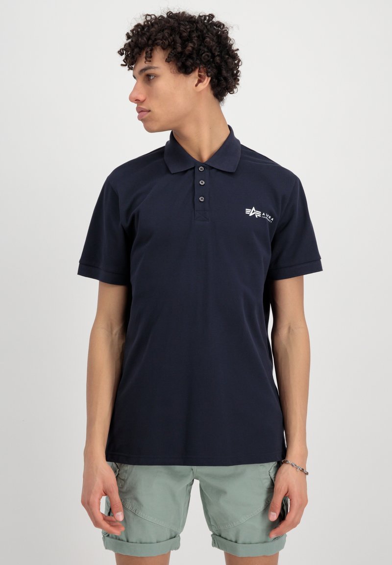 Polo shirt blu navy con maniche corte, colletto a tre bottoni e logo ricamato sul petto, realizzato in tessuto morbido e liscio.