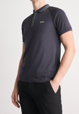 Slim-Fit-Polohemd in Dunkelgrau, mit farblich abgesetztem Kragen in Grün, kurzen Ärmel und kleinem Logo auf der Brust. Glatte Textur.