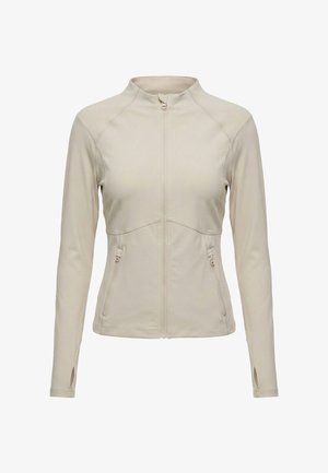 Beige Jacke mit langen Ärmeln, Frontreißverschluss, zwei seitlichen Reißverschlusstaschen, hohem Kragen und Daumenlöchern an den Ärmeln.