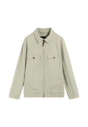 Veste beige zippée à manches longues, avec deux poches à rabat boutonnées sur le devant, deux poches fendues sur les côtés, ourlet élastique et col classique.