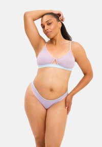 Lyxig bralette och matchande stringtrosor i mjuk lavendel och pastellrosa, med en triangulär design som har kontrasterande kant och en nyckelhålsdetalj.