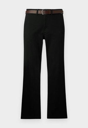 Schwarze gerade Hosen mit Fronttaschen, kombiniert mit einem braunen Leder-Gürtel mit einer silbernen Schnalle.