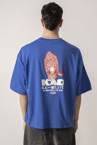 Blue cotton t-shirt with a relaxed fit. Features a printed leopard design in red on the back, along with brand text in white and Japanese characters.