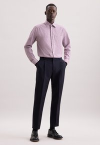 Rood en wit geblokt overhemd met een kraag, gecombineerd met donkerblauwe op maat gemaakte broeken en zwarte nette schoenen. Eenvoudig ontwerp, nauwsluitende silhouet.