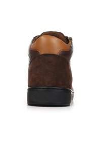 Bruine suède hoge sneakers met een tan leren hiel en een zwarte rubberen zool. Heeft een gestructureerd patroon en een rits aan de zijkant.