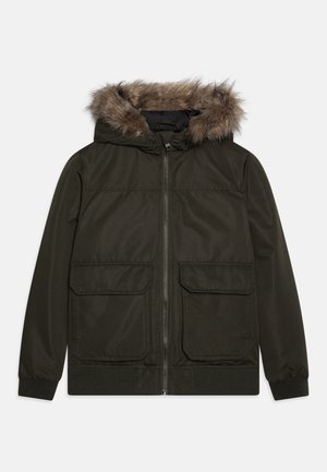 Tamsiai žalia striukė su kailio pamušalu ant gobtuvo, dviem priekinių kišenių, ir elastingomis rankovėmis. Pagaminta iš lygaus audinio su tekstūruotu paviršiumi.