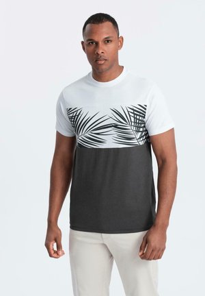 Camiseta de manga corta con una sección superior blanca decorada con un estampado de hojas de palmera y una sección inferior de color gris oscuro, confeccionada en tejido suave.