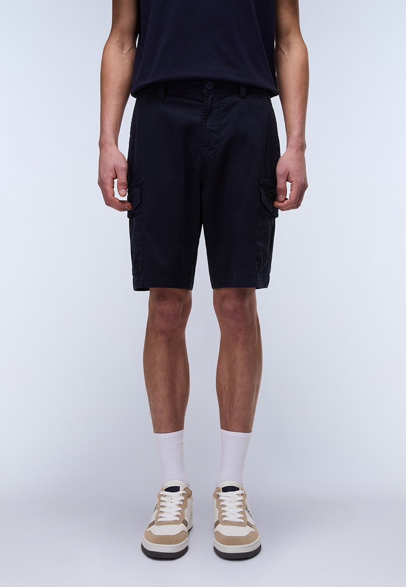 Marine Cargo Shorts laget av bomull, med sidelommer, avslappet passform og knelengde. Kombinert med beige og hvite joggesko.