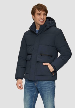 Marineblauer Pufferjacke mit Kapuze, ausgestattet mit einem Frontreißverschluss, zwei Seitentaschen und einer Brusttasche mit Reißverschluss. Glatte Stoffoberfläche.