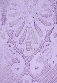 Țesătură din dantelă lavandă, cu modele florale intricate și detalii geometrice. Textură moale cu un aspect delicat, țesut.