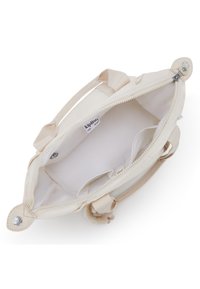 Cremfarbige Handtasche aus strukturiertem Stoff, mit Reißverschlussverschluss, zwei Griffen und einer Innentasche. Verfügt über einen dekorativen Pom-Pom-Akzent.