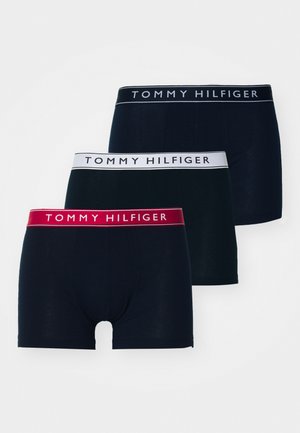 Three pairs of Tommy Hilfiger boxer briefs in navy and black, with elastic waistbands featuring the brand logo in white and red.