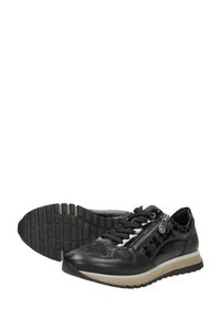 Chaussures de sport noires avec un dessus texturé et des perforations, semelle contrastante, accents métalliques et fermeture éclair.