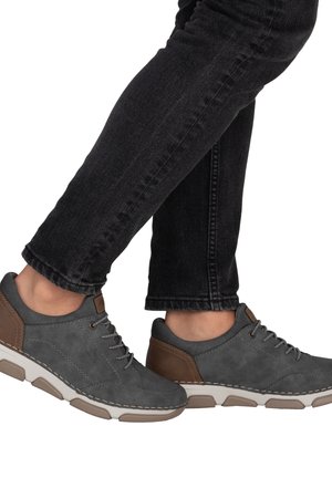 Graue Leder-Schnürschuhe mit braunen Akzenten, ausgestattet mit einer Gummisohle mit strukturiertem Grip und kontrastierenden Ziernähten.