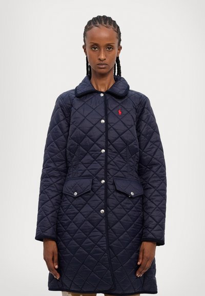 Kvalitatīvs tumši zils jakas mētelis ar asu apkakli, pogām ar uzspiedi, sānu kabatām un mazu sarkanu logo kreisajā krūtī. Aizraujoša dimanta tekstūra.