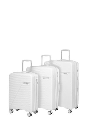 Three white hard-shell suitcases of different sizes with four spinner wheels and extended telescopic handles, arranged side by side.