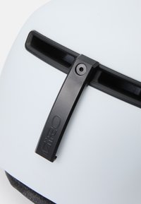 Hvid hjelm med mat finish, udstyret med en sort visirbeslag med en fastholdelsesskrue og et tekstureret stofinteriør.