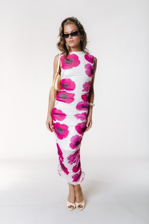 Valge sobitatud kleit roosade ja mustade lillemustritega, ümmarguse kaelusega ja külgmiste kortsus detailidega. Kandmisega heledate beežide avatud varbaga kontsakingadega.