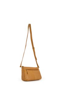 Sac bandoulière en cuir marron avec une sangle ajustable, poche zippée à l'avant, texture lisse et forme rectangulaire. Design minimaliste.