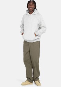 Szara bluza z kapturem i ściągaczem, z kangurzą kieszenią, w zestawieniu z oliwkami spodniami cargo i beżowymi mokasynami.