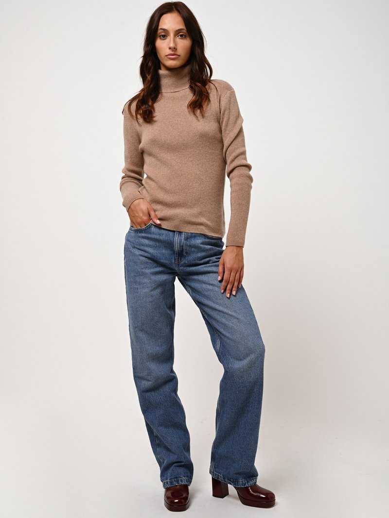 Beige coltrui met geribbelde manchetten, gecombineerd met loszittende blauwe jeans en bordeaux blokhak schoenen. Eenvoudig en casual design.
