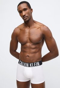 Άσπρα βαμβακερά boxer briefs με μαύρη ζώνη μέσης με λογότυπο Calvin Klein. Κλασική εφαρμογή με ομαλή υφή και σχεδιασμό κοντού ποδιού.