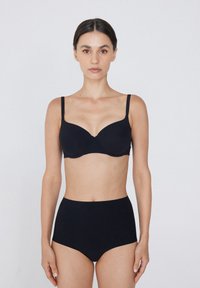 Czarny biustonosz z wyściółką, z regulowanymi ramiączkami i gładkim materiałem. W połączeniu z czarnymi majtkami typu high-waist. Prosty design, brak widocznych logo.