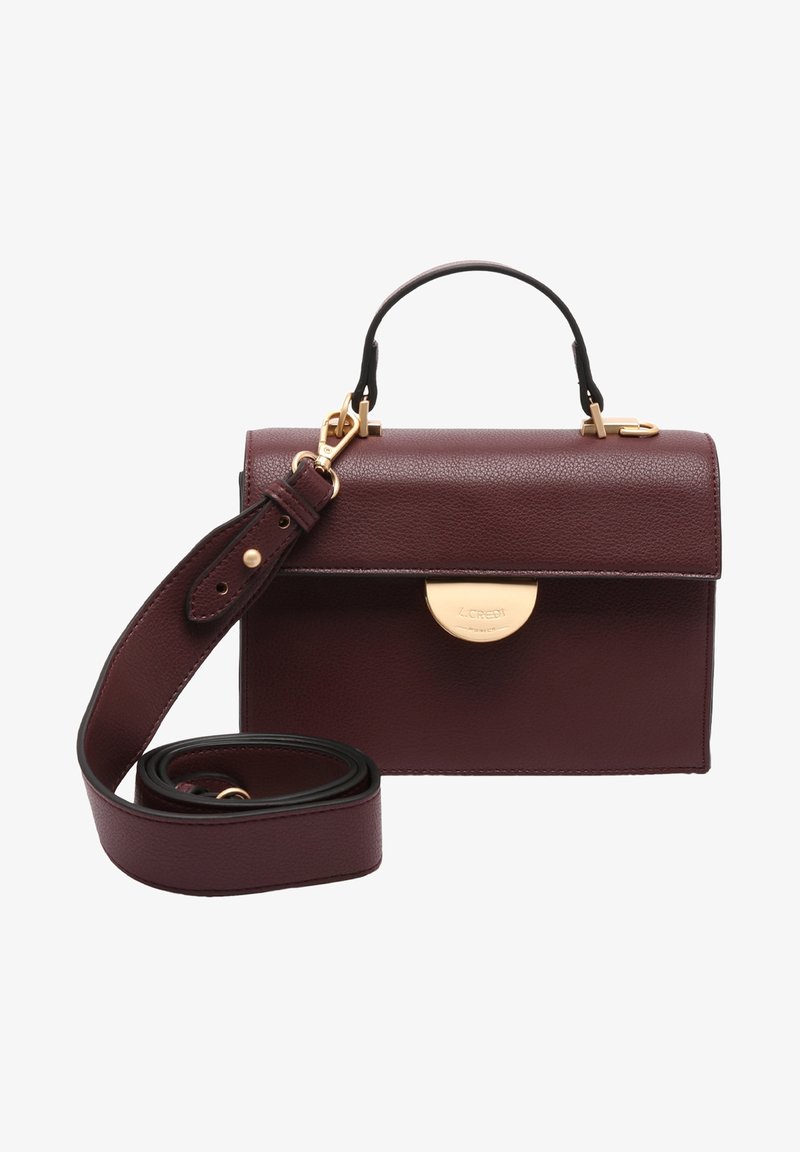 Sac à main en cuir marron foncé avec fermoir doré, poignée courte, et bandoulière longue ajustable détachable enroulée à côté du sac.