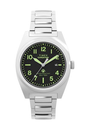 Stříbrné náramkové hodinky Timex Expedition s černým ciferníkem, zelenými luminiscenčními čísly a ručičkami, datumovým okénkem na 3. hodině a kovovým řemínkem.