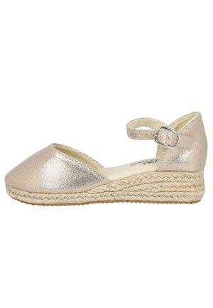 Alpargata de cuña metálica beige con puntera cerrada, correa en el tobillo y suela trenzada de yute.