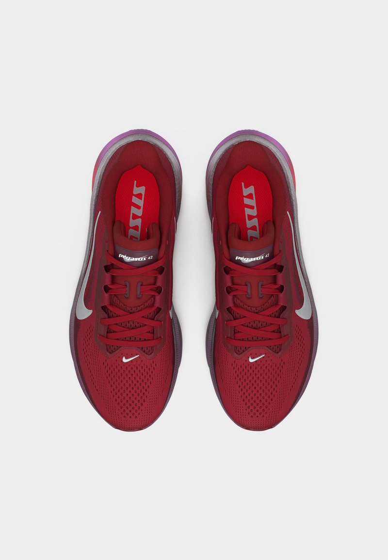Paire de chaussures de course Nike rouges avec logos swoosh blancs, tiges en mesh respirant et lacets, vues de dessus.