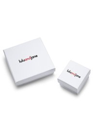 Divi balti ar matētu virsmu; lielākais balts ir kvadrātveida, bet mazākais ir nedaudz mazāks un kubveida. Abi rāda logo "luluandjane" melnā un sarkanā krāsā.