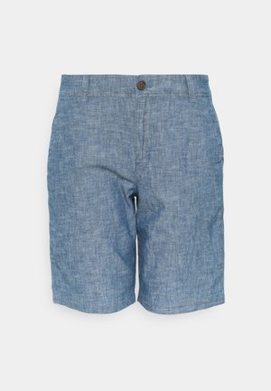 Shorts chambray bleus pour homme avec fermeture bouton, passants de ceinture et poches latérales sur fond blanc.