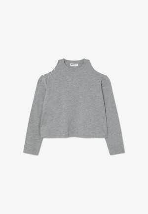 Sudadera gris de manga larga con diseño de hombros al aire, adornada con tachuelas plateadas en los hombros y con un dobladillo corto para un look moderno.