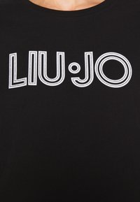 Maglietta nera a girocollo con logo "LIU JO" bianco contornato al centro del petto.