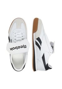 Reebok sporta apavi ar baltu ādas augšdaļu, melniem akcentiem, mīkstu zamšādas apdari, mīkstinātu mēli un Velcro siksnu. Gumijas zole.