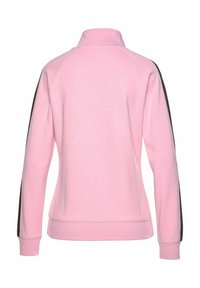 Sudadera de color rosa claro con cuello alto, mangas largas con rayas laterales negras, puños acanalados y un acabado de tela texturizada.