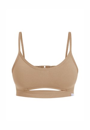 Soutien-gorge de sport beige avec des bretelles fines, un détail de découpe au centre et une texture côtelée. Présente une petite étiquette logo sur le côté.