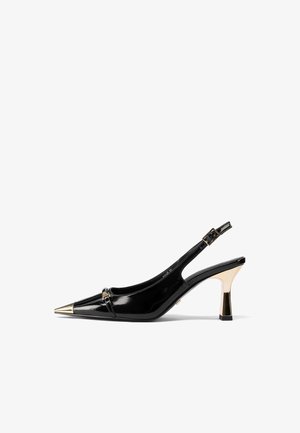 Décolleté in vernice nera con punta appuntita, accento in metallo dorato sulla punta e tacco medio a blocco.