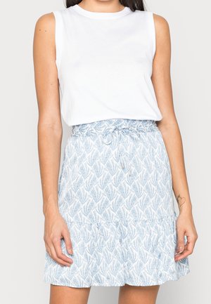 Biały top bez rękawów zestawiony z jasnoniebieską spódnicą z wzorem liści, elastyczną talią i subtelną falbanką u dołu.