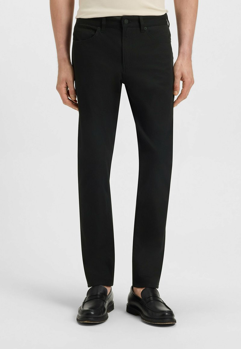 Black trousers made of cotton blend, slim fit, with front and back pockets, metal button closure, and belt loops. Smooth texture.